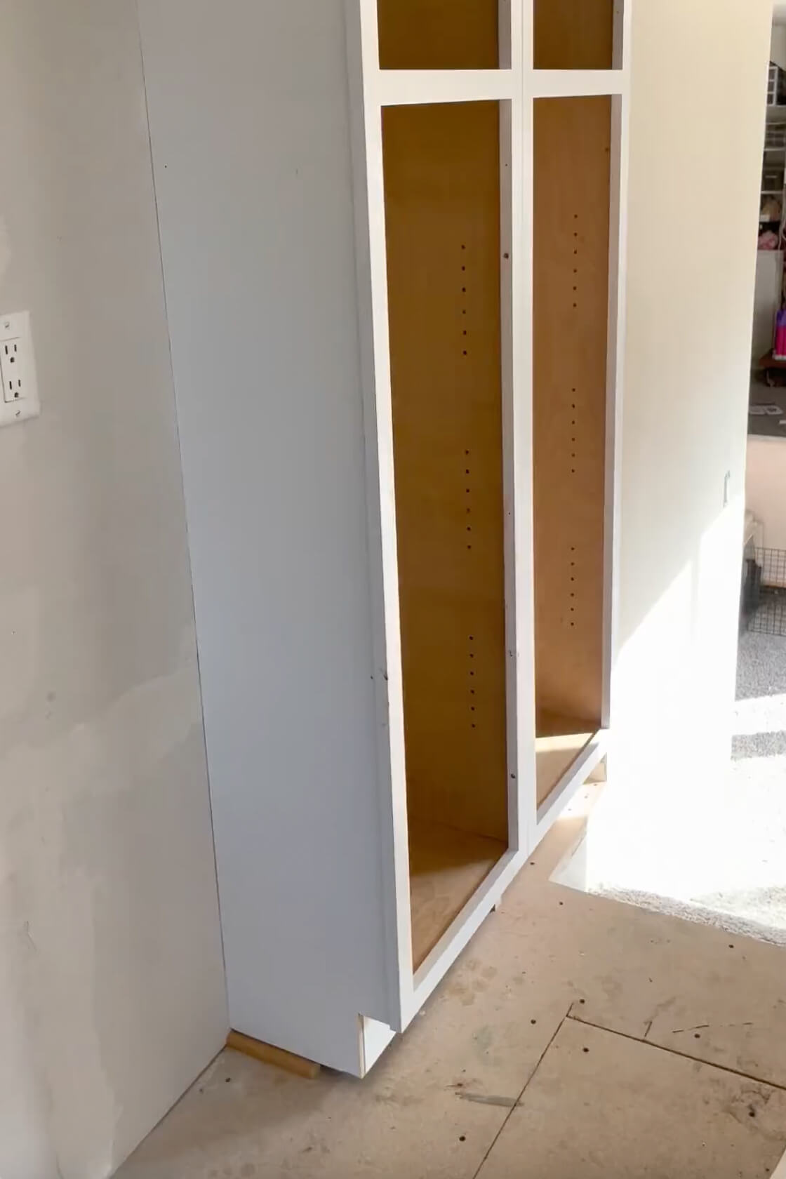 Using shims to level a cabinet on an uneven floor.